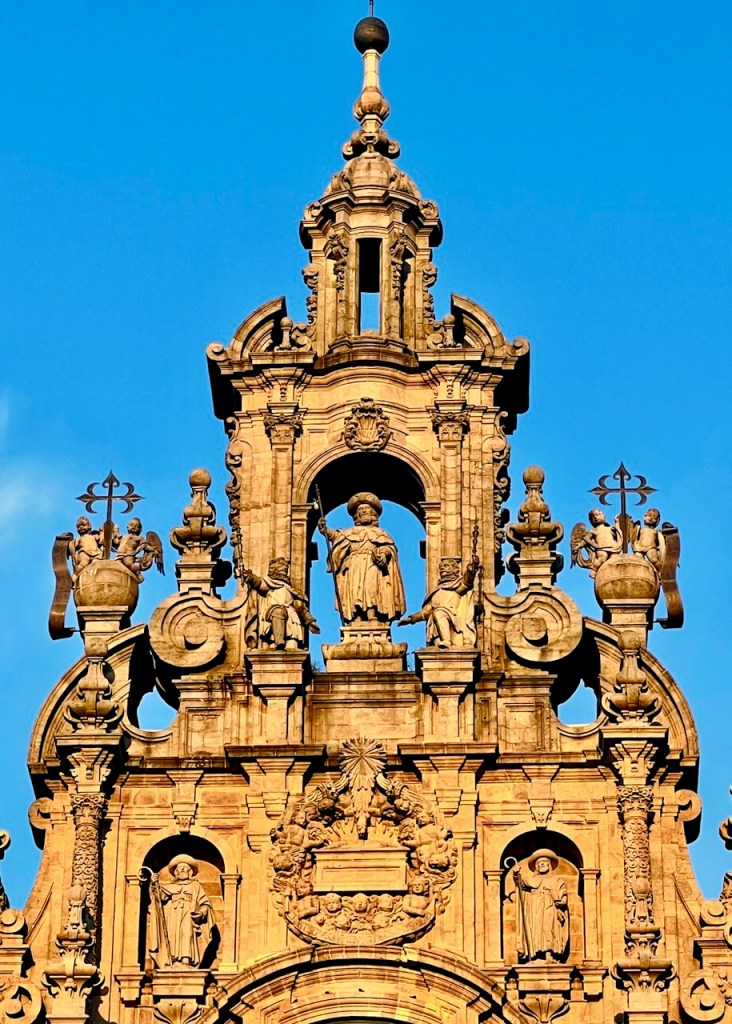 Ornate architectural facade featuring sculptures and intricate detailing against a clear blue sky.